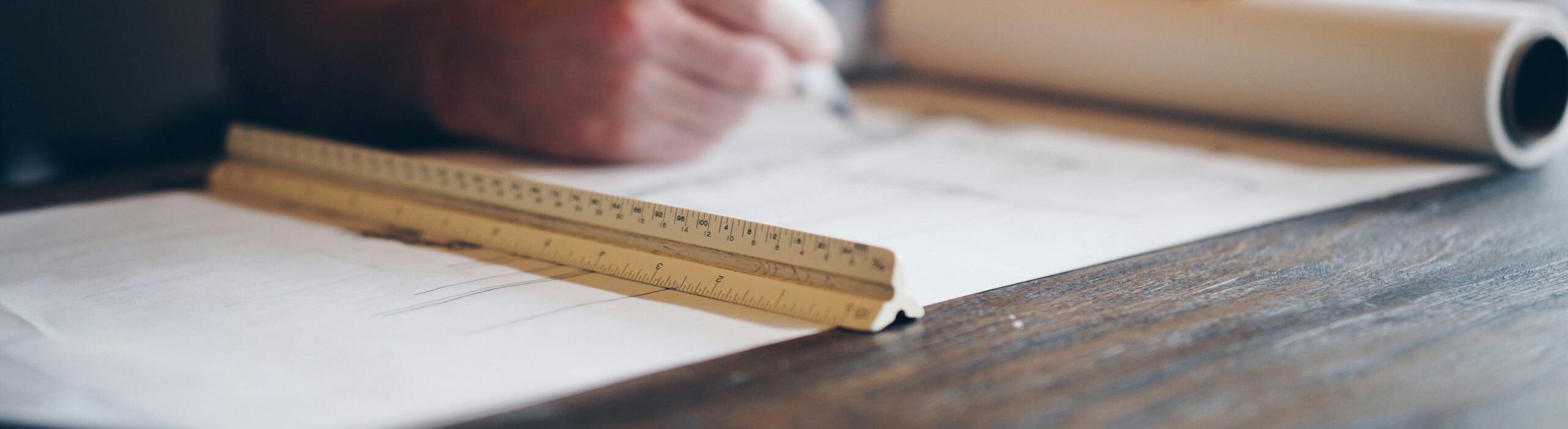 Person with blueprints and ruler | Construction Process | Kenny Construction Group